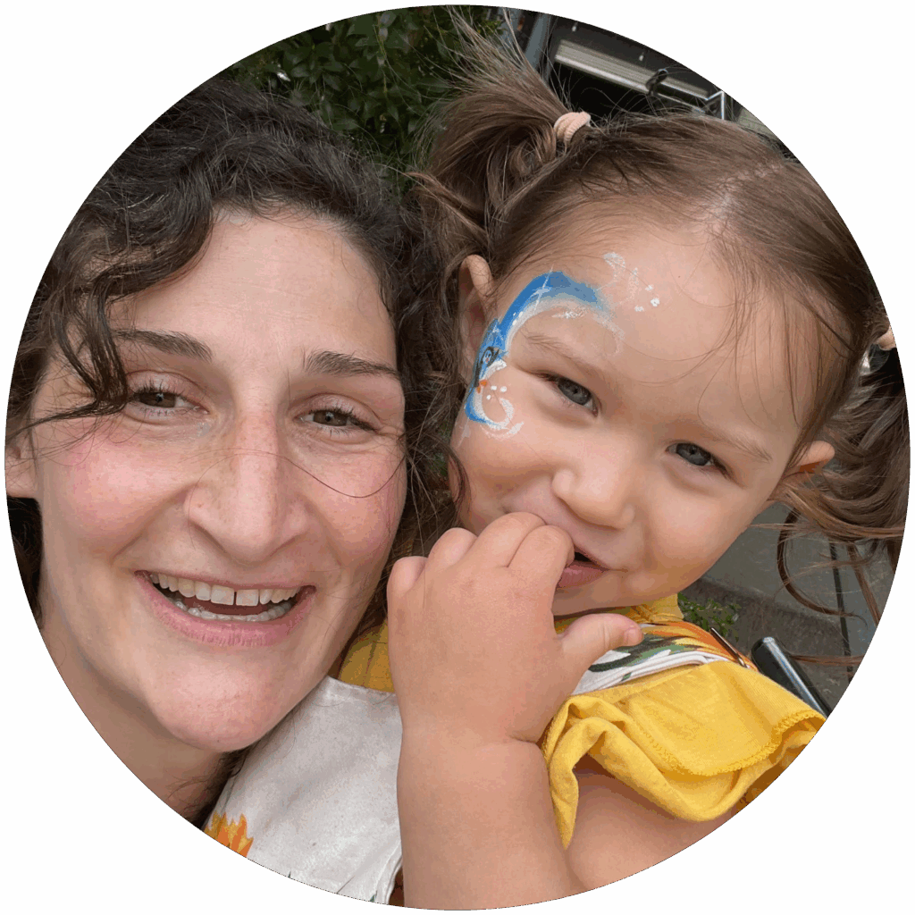 Picture of Mariah Holes. Mariah has curly dark brown hair, light skin, and is holding a young child.